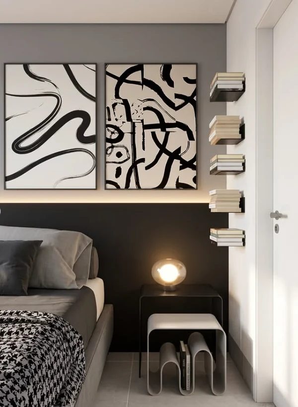Detalhe da cabeceira, quadros abstratos, livros e luminária acesa ao lado da cama do AP Entre Tons.