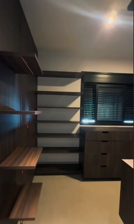 Registro da execução do closet com prateleiras abertas, gaveteiro e janela ao fundo.